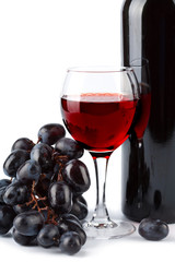 glass of red wine, bottle and grapes isolated