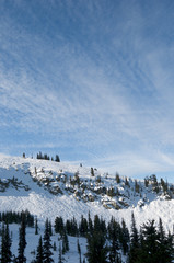 Snow covered peak under thin clouds