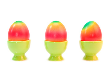 colorful eggs in eggcups isolated on white.