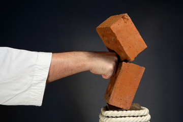 karate man breaking  brick on gray background © Andrey Ushakov