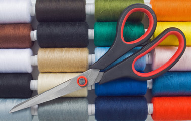 closeup of multicolored sewing spools and scissors