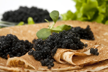 pancake with black caviar and greens