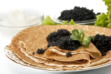 served place setting: pancake with black caviar