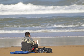 Fototapeta na wymiar Młoda czytanie na plaży