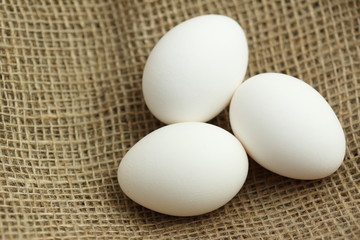 three eggs on brown fabric texture