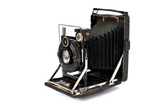 Ancient photographic camera with lens of bellows over white