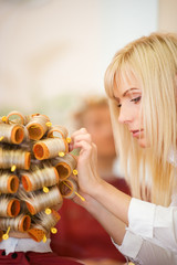 Naklejka premium Female hairdresser working in beauty salon