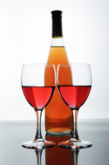 A bottle and glasses of rose wine