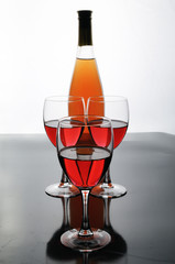 A bottle and glasses of rose wine