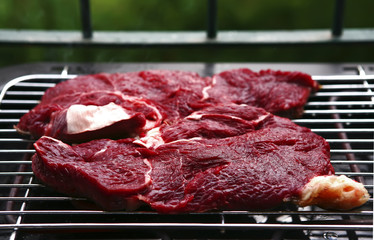 two raw steak on brazier