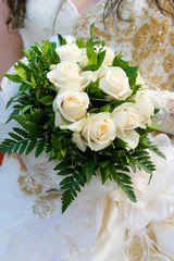 An image of a bride holding her bouquet of roses