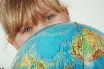 Europäisches Mädchen mit blauen Kinderaugen und Weltkugel
