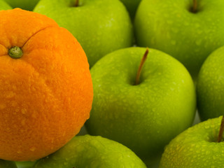 Wet Green Apples and Orange Background