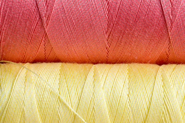 bobine di filo da cucito gialla e rosa