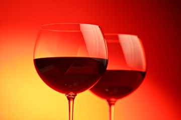 Wine glasses against red background