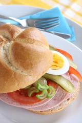 belegtes brötchen mit bierwurst, ei, gurke und tomate