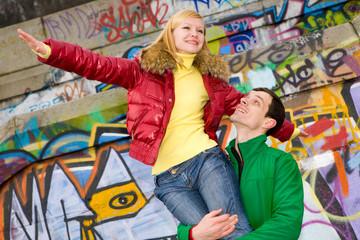 Obraz na płótnie Canvas Happy smiling love couple fly backdrop of graphite wall