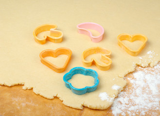 Mixed cookie cutters on wooden table.