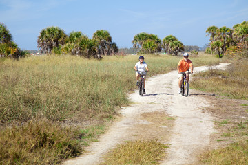 Obraz premium Seniors Riding Bikes at Beach