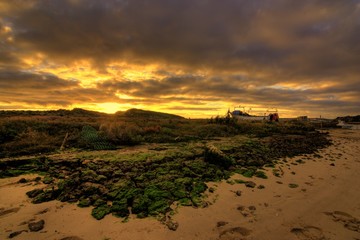 Sky with clouds,send dunes and fishing boat