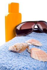 towel, shells, sunglasses and lotion