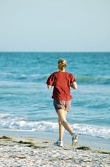 Young woman jogging along the beach.