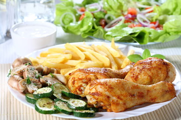 Roasted chicken legs with chips and vegetables