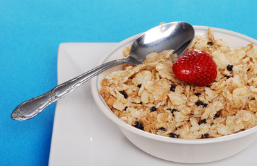 bowl of cereal with blueberries strawberry and a spoon