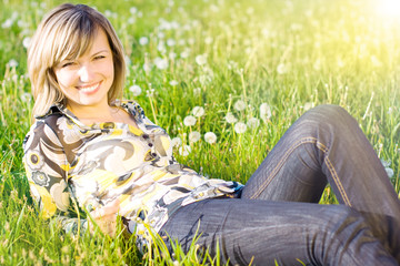 Happy young girl enjoying the sun on a green meadow
