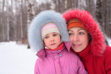 Mother with child in wood in winter