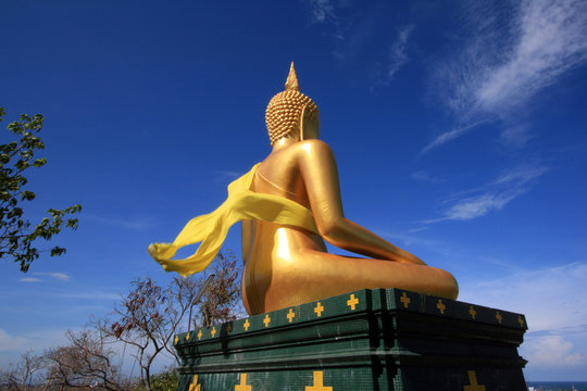 side view of golden buddha statue with gold scarf