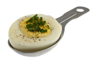 hard-boil egg with green chives on tablespoon