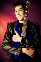 Fototapeta premium handsome young man embracing his guitar