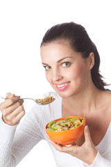 Young woman eating cereal muslin with kiwi, isolated