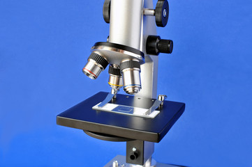 Close-up of a microscope isolated on blue
