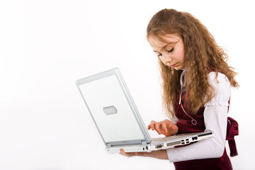 Adorable school girl holding a laptop computer