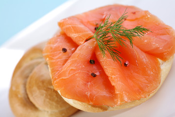 Smoke salmon on bagel with freshly black pepper.