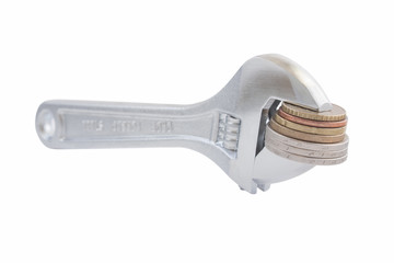 Steel wrench with coins isolated on white background