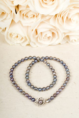Black Pearl Necklace and a Bouquet of White Roses