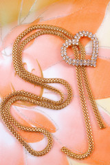 Jewelry with heart on background silk fabrics