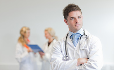 Fototapeta premium Doctor with two femal doctors in the background