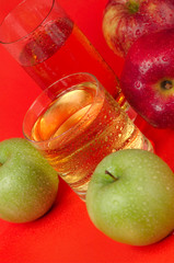 Juicy red and green apples on a red background