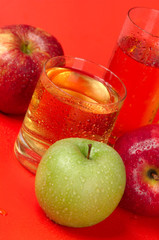 Juicy red and green apples on a red background