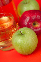 Juicy red and green apples on a red background