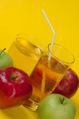 Juicy red and green apples on a yellow background