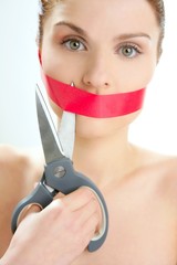 Beautiful woman with red tape on mouth portrait