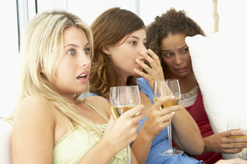 Obraz na płótnie Canvas Female Friends Watching A Scary Movie Together