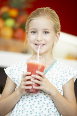 Young Girl Drinking A Berry Smoothie