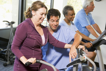 Fototapeta na wymiar Nurse With Patient In Rehabilitation Using Exercise Machine