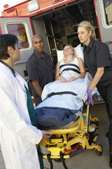 Paramedics and doctor unloading patient from ambulance © Monkey Business